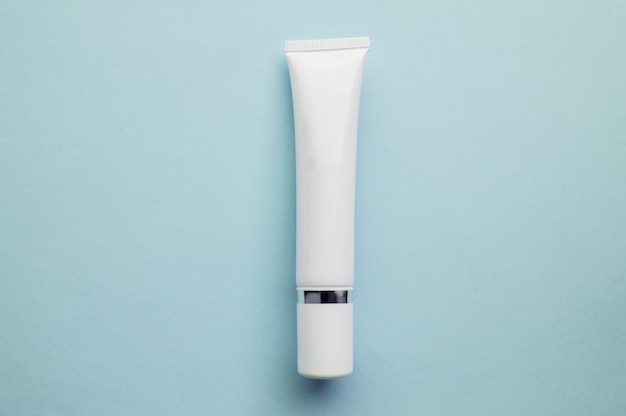 Tube blanc vierge de crème isolé sur bleu