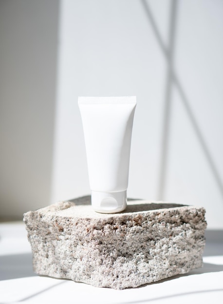 Tube de crème blanc propre avec des ombres à la mode et une texture de pierre