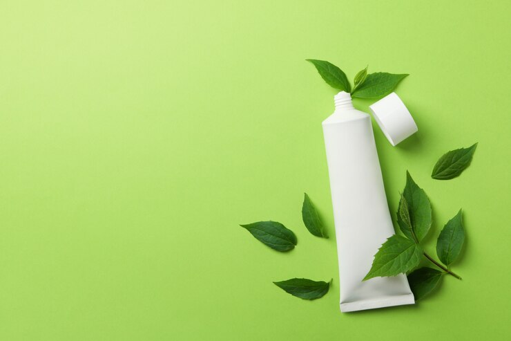 Photo tube de dentifrice et feuilles de menthe sur une surface verte