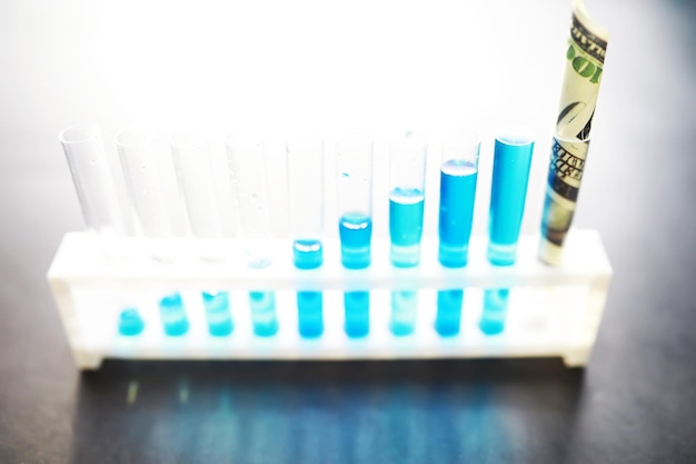 Tube à essai avec liquide bleu sur la table de laboratoire Examen du liquide au microscope