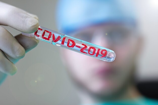 tube à essai médical avec Coronavirus COVID 2019 entre les mains d'un chercheur d'un médecin scientifique