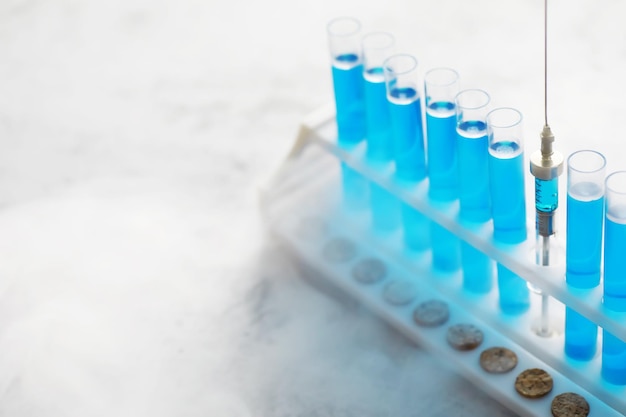 Le tube à essai de verre déborde de la nouvelle solution liquide de bleu de potassium effectue une réaction d'analyse prend différentes versions de réactifs à l'aide de produits chimiques pharmaceutiques contre le cancer .