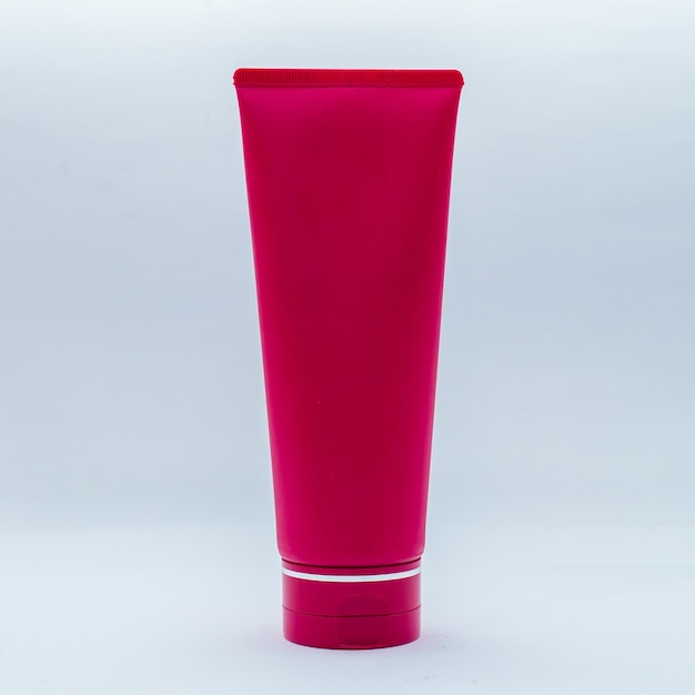 Photo un tube de lotion rose est sur un fond blanc.