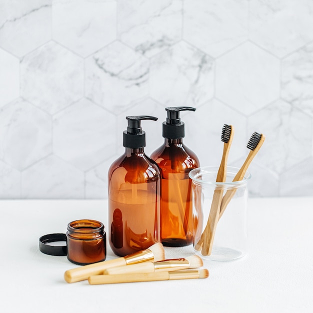 Tube de toilette dans un intérieur de salle de bain, gel douche, shampoing et brosses à dents en bambou.