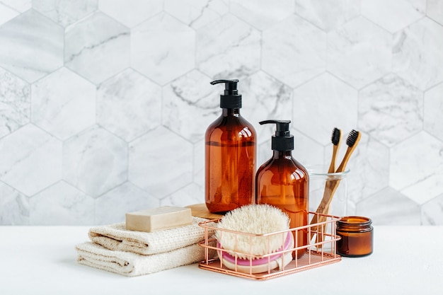 Tube de toilette dans un intérieur de salle de bain, gel douche, shampoing et brosses à dents en bambou.