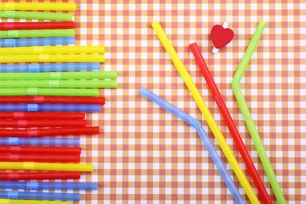 Des tubes à cocktail colorés se trouvent sur un fond de couleur vive