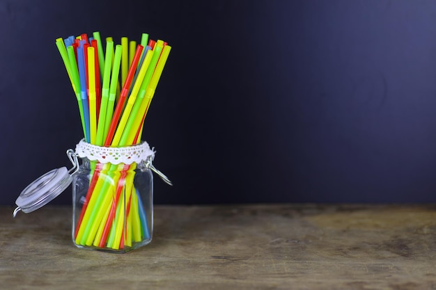 Tubes à cocktail en plastique colorés debout dans une vue latérale en verre