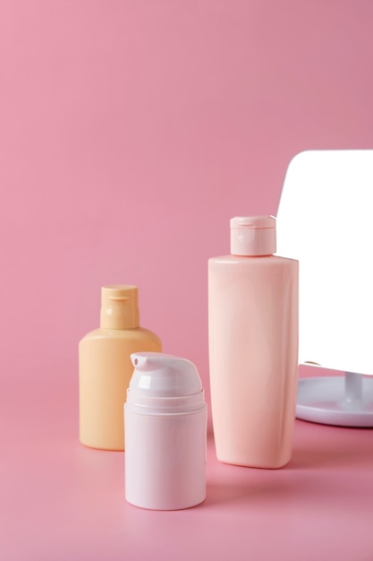 Tubes de crème cosmétique, produit pour le visage, emballage de bouteille vierge de soins de la peau sur fond rose. Concept de beauté et spa.