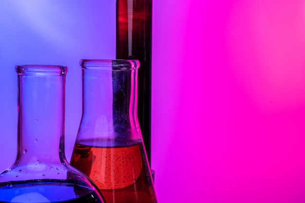 Tubes en verre de laboratoire avec des produits chimiques sur rose vif