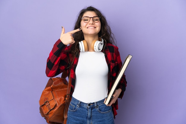 Étudiant adolescent isolé sur un mur violet donnant un geste de pouce en l'air