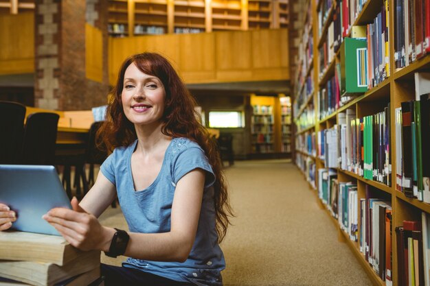 Étudiant adulte souriant dans la bibliothèque