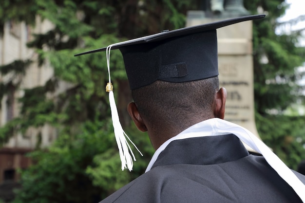 Étudiant africain sous la forme d'un diplômé universitaire par derrière gros plan