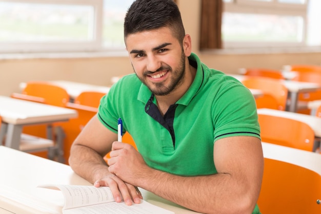 Étudiant arabe avec des livres assis dans la salle de classe