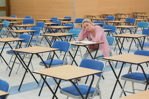 Étudiant assis au bureau dans la salle d&#39;examen vide