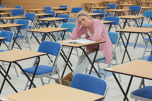 Étudiant assis à la pensée de bureau