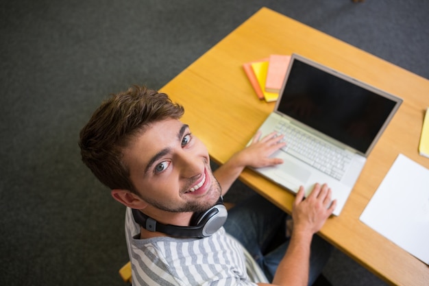 Étudiant à la bibliothèque avec un ordinateur portable