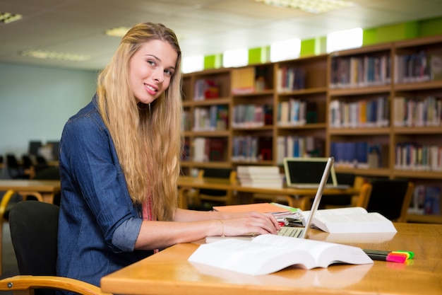 Étudiant à la bibliothèque avec un ordinateur portable