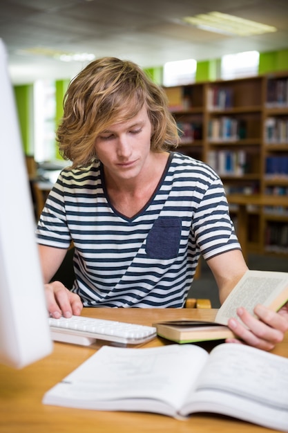 Étudiant à la bibliothèque avec ordinateur