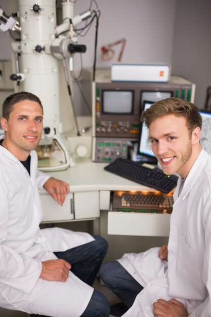 Étudiant de biochimie à l&#39;aide de grand microscope et ordinateur