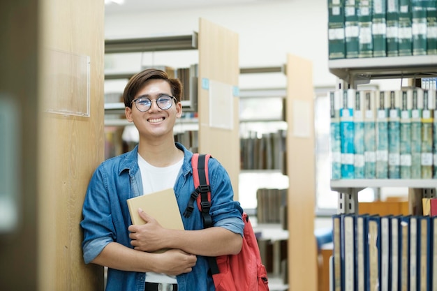 Étudiant choisissant et lisant un livre à la bibliothèque