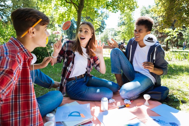 Étudiant choqué. Étudiant aux cheveux noirs vêtu d'une chemise blanche se sentant très choqué lors d'un brainstorming avec des amis