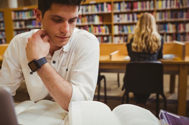 Étudiant ciblé à l&#39;aide de son ordinateur portable tout en travaillant dans la bibliothèque