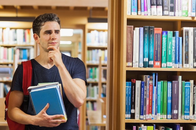 Étudiant debout à la bibliothèque