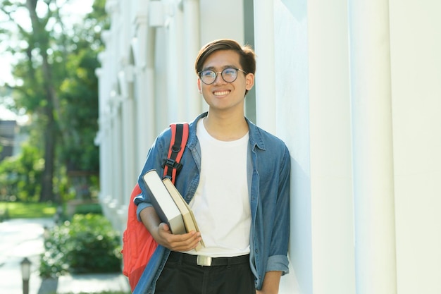 Étudiant debout en plein air et tenant des livres