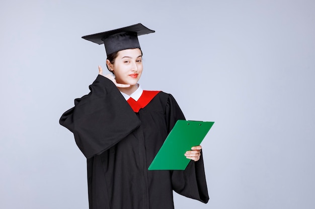 Étudiant diplômé avec diplôme gesticulant appelez-moi. photo de haute qualité