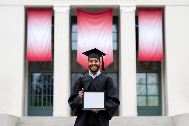 Étudiant diplômé tenant un cadre vierge