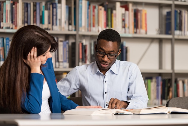 Étudiant endormi assis et s'appuyant sur une pile de livres au collège faible profondeur de champ