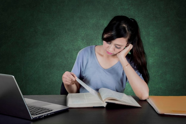 Étudiant ennuyé lisant un livre en classe