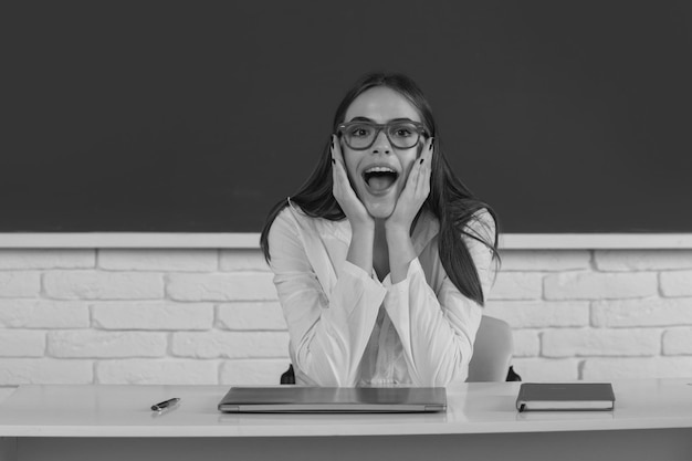 Étudiant étonné jolie jeune femme en classe à l'école secondaire étudiant surpris en classe étonné