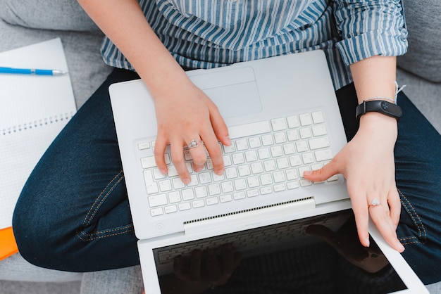 Étudiant étudiant à domicile travaillant avec son ordinateur portable à faire ses devoirs de près. L'enseignement à distance concept pendant la quarantaine