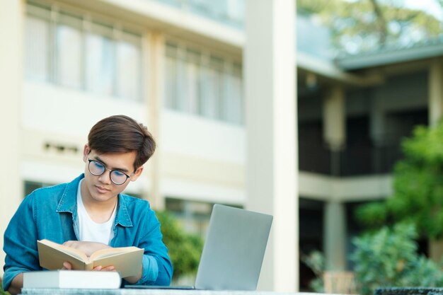 Étudiant étudiant en plein air à l'aide d'un ordinateur portable