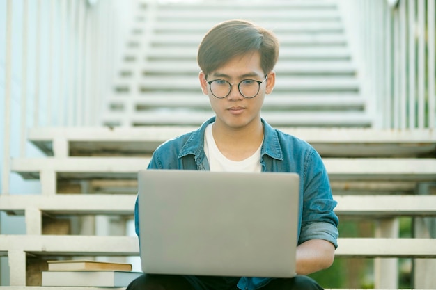 Étudiant étudiant en plein air à l'aide d'un ordinateur portable