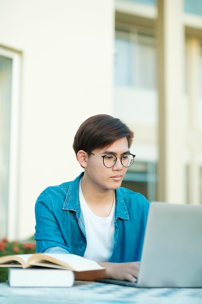 Étudiant étudiant en plein air à l'aide d'un ordinateur portable