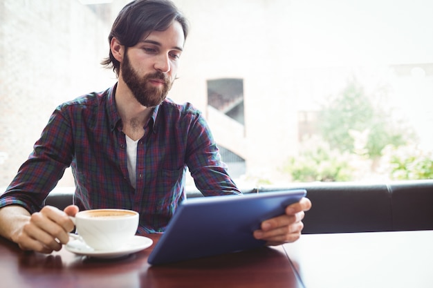 Étudiant hipster avec tablette à la cantine