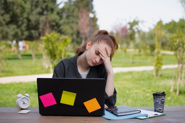 Étudiant indépendant fatigué assis à table les yeux fermés