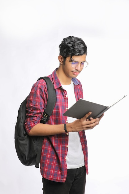 Étudiant indien debout avec sac et lecture de produits laitiers sur fond blanc.