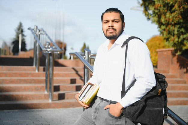 Étudiant indien avec sac à dos tenant des livres à la journée ensoleillée