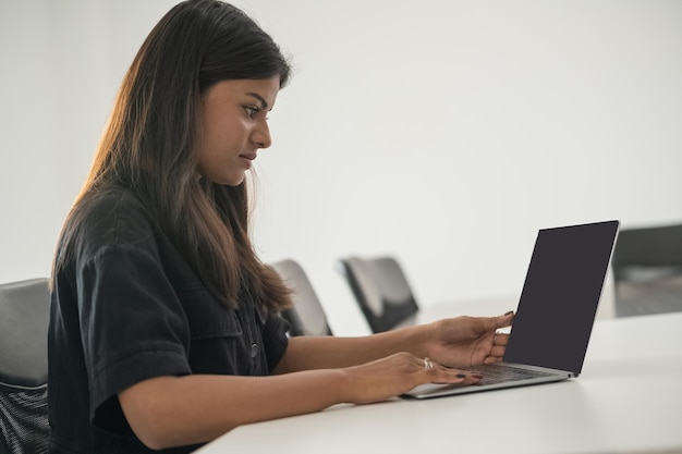 Étudiant indien utilisant un ordinateur portable dans la salle de la bibliothèque