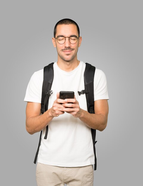 Étudiant inquiet pointant vers le haut et utilisant son téléphone portable