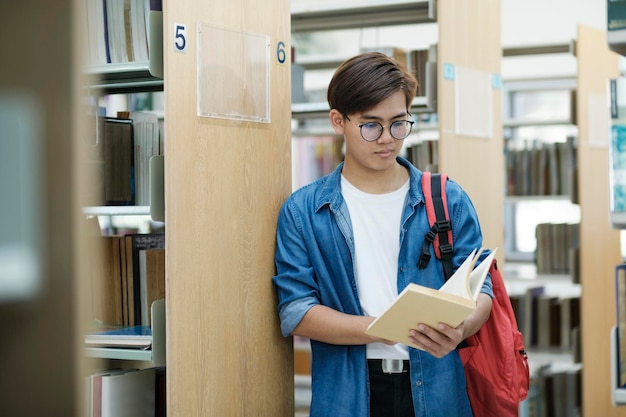 Étudiant lisant un livre à la bibliothèque