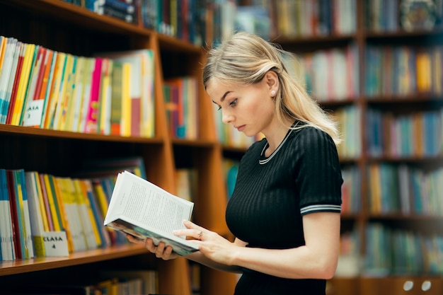 Étudiant lisant un livre dans la bibliothèque