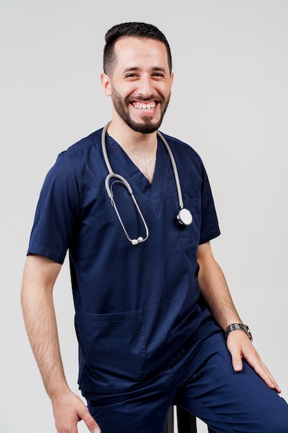Étudiant en médecine arabe avec stéthoscope en uniforme chirurgical sourit