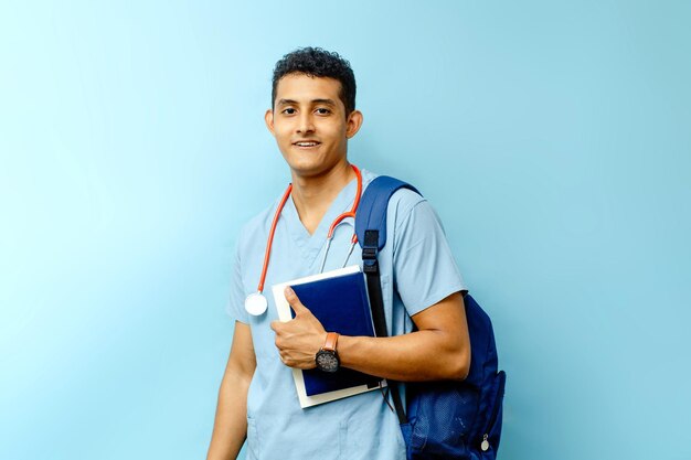 Étudiant en médecine avec sac à dos tenant des livres en regardant la caméra