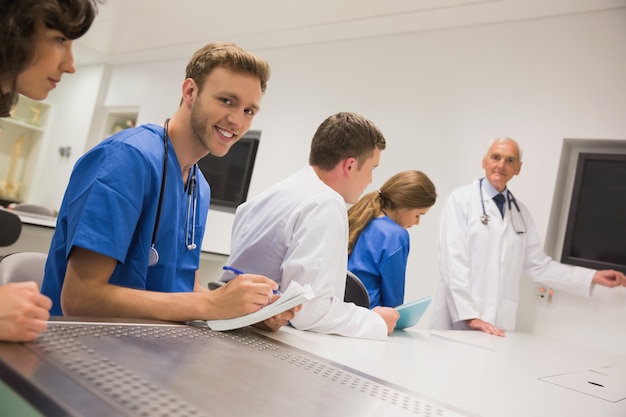 Étudiant en médecine souriant à la caméra pendant le cours