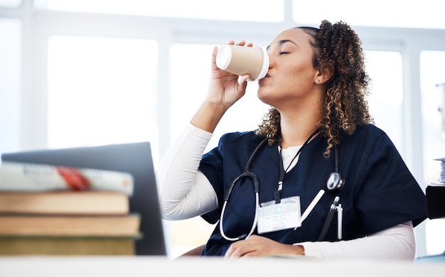 Étudiant en médecine technologie et boire du café à l'hôpital étudiant des livres d'éducation sur l'épuisement professionnel recherche ou apprentissage du bien-être Infirmière fatiguée ou femme de soins de santé avec un ordinateur portable ou un stage en médecine