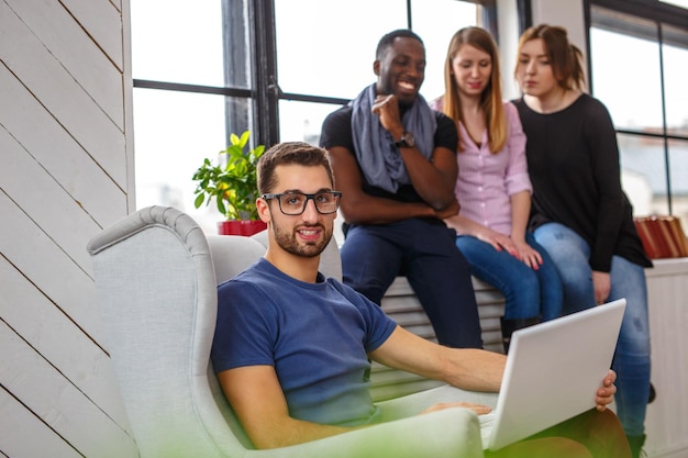 Étudiant multiethnique utilisant un ordinateur portable dans des appartements.